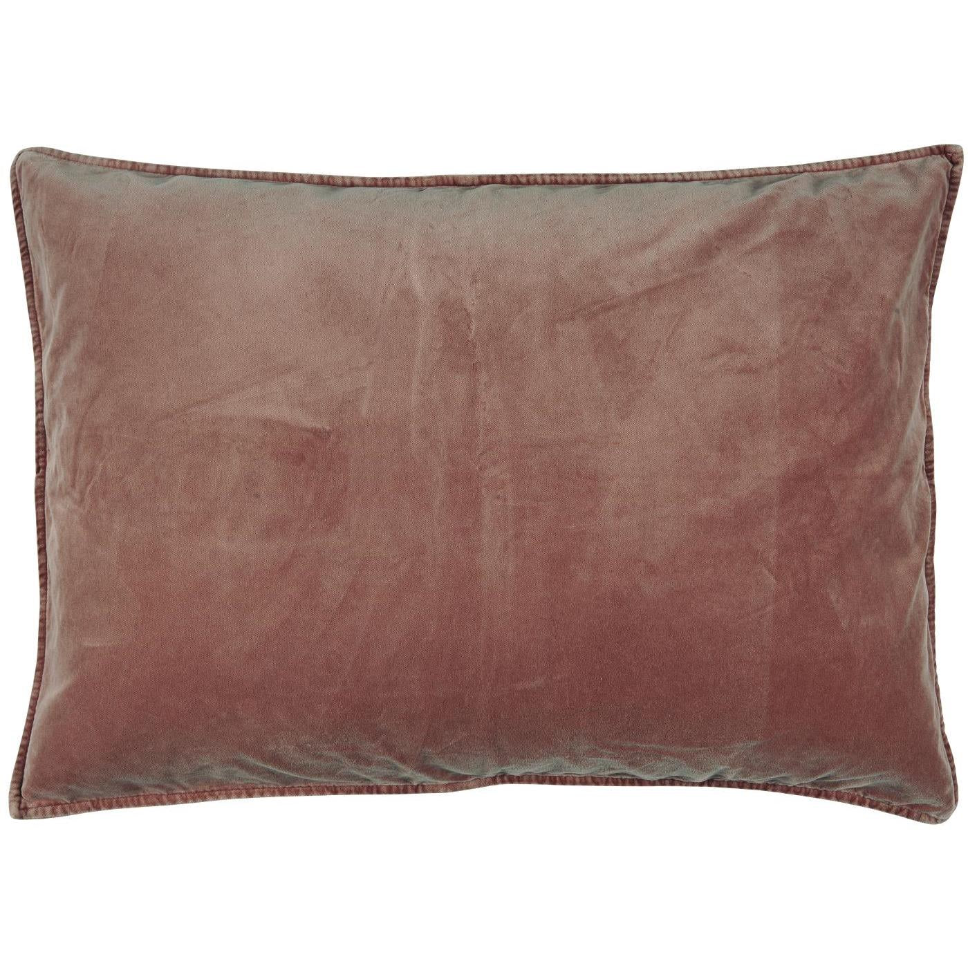 Coussin rectangulaire en velours doux de couleur rouille, avec des bords finement cousus. Le tissu velouté reflète la lumière de manière subtile, ajoutant de la profondeur à la texture luxueuse du coussin.