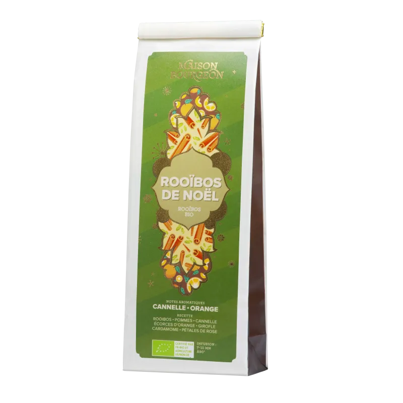 Paquet de rooibos "Rooibos de Noël" de la Maison Bourgeon, au design vert et doré. Ce mélange bio est aromatisé avec des notes de cannelle et d'orange, et contient des pommes, écorces d'orange, girofle, cardamome et pétales de rose. Une infusion aux saveurs épicées et fruitées, parfaite pour célébrer les fêtes de fin d'année.