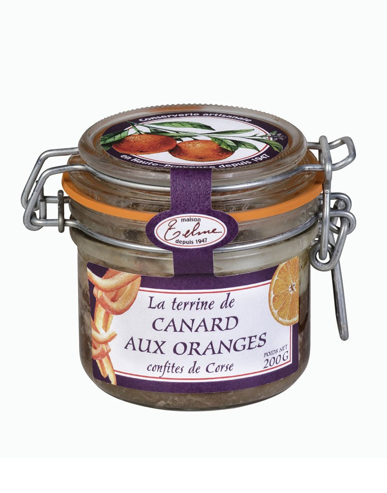 Terrine de Canard aux Oranges Confites de Corse de la Maison Telme, présentée dans un pot en verre avec une étiquette violette. L'étiquette met en avant des illustrations d'oranges, évoquant le mariage de saveurs entre le canard et l'orange confite, une spécialité artisanale de Haute-Provence.