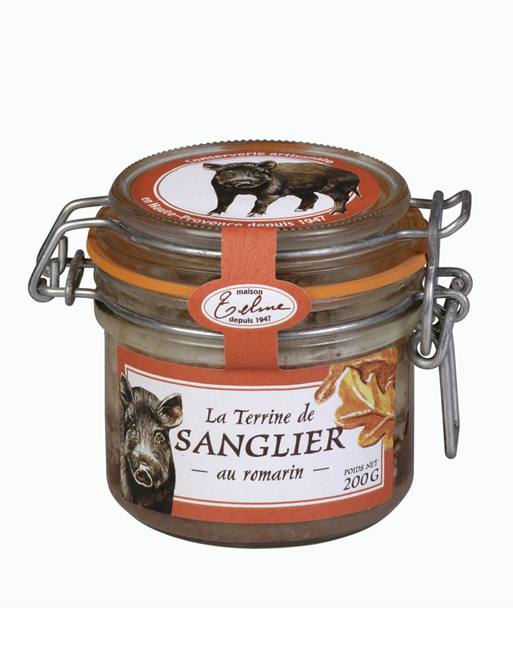 Terrine de Sanglier au romarin, présentée dans un pot en verre de la Maison Telme, depuis 1947. L'étiquette orange montre une illustration de sanglier et met en avant le goût rustique de cette spécialité artisanale de Haute-Provence, rehaussée par des notes de romarin.